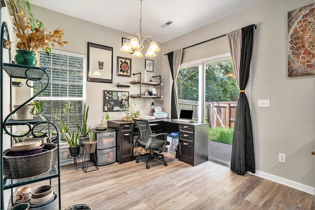 office space with light wood-type flooring and an inviting chandelier