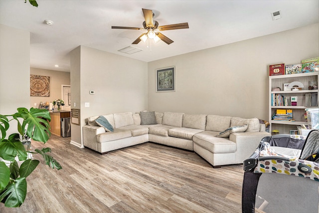 living room featuring ceiling fan and light hardwood / wood-style floors