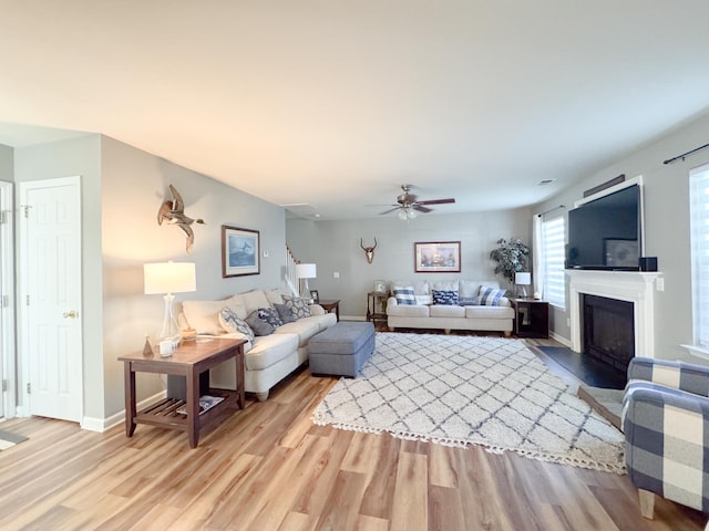 9229 N Moreto Cir, Summerville, SC 29485 - living area with light wood-style flooring, a ceiling fan, a fireplace with flush hearth, and baseboards