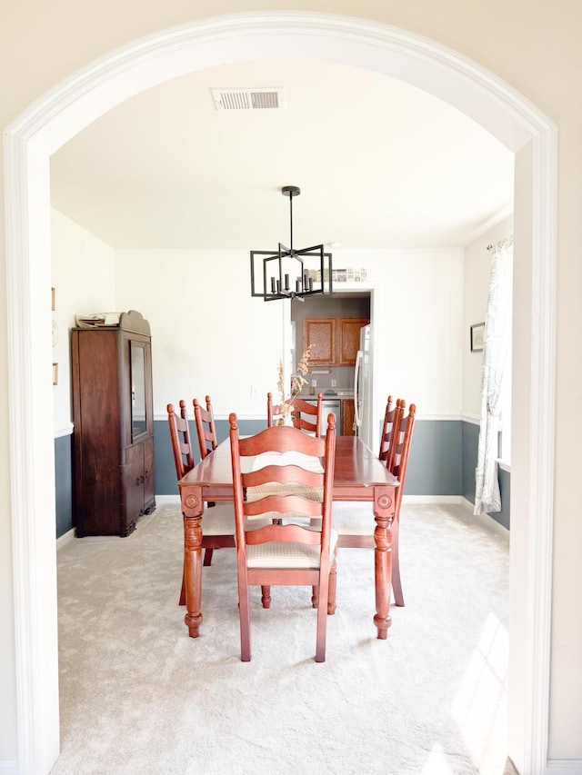 9229 N Moreto Cir, Summerville, SC 29485 - dining space with arched walkways, light carpet, a chandelier, and baseboards