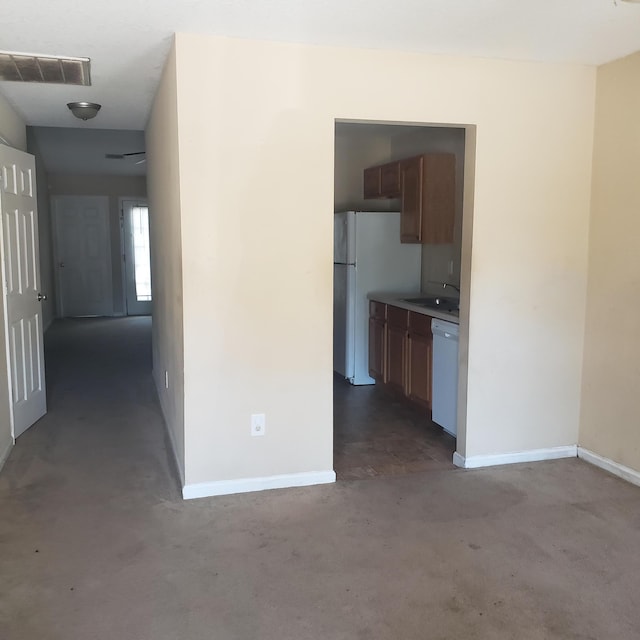 kitchen with white appliances, visible vents, light countertops, concrete floors, and a sink