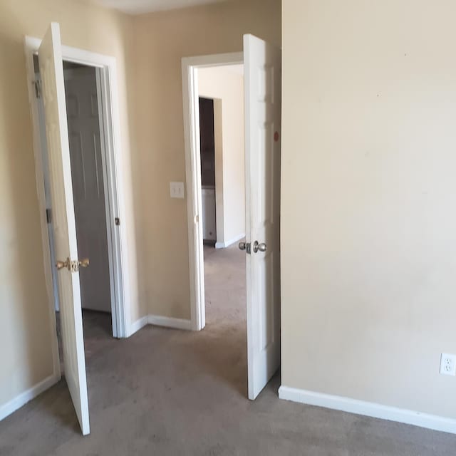 corridor featuring carpet floors and baseboards