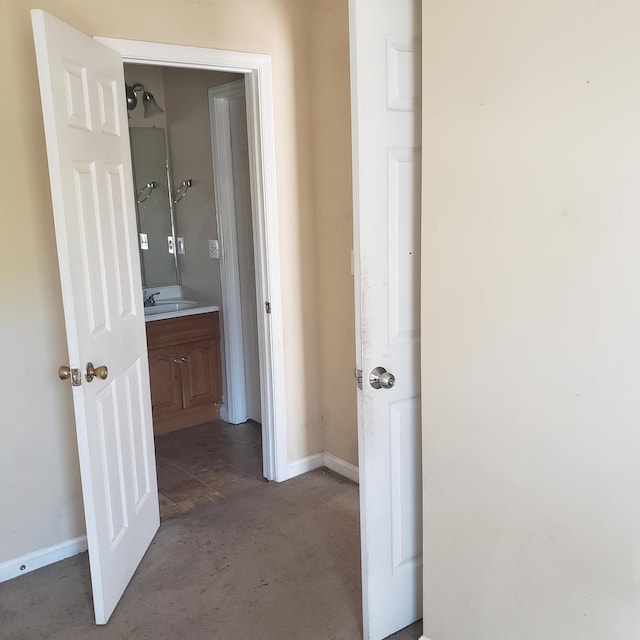 hallway featuring a sink and baseboards