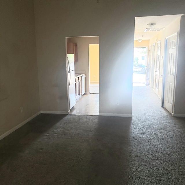 unfurnished room with carpet and baseboards