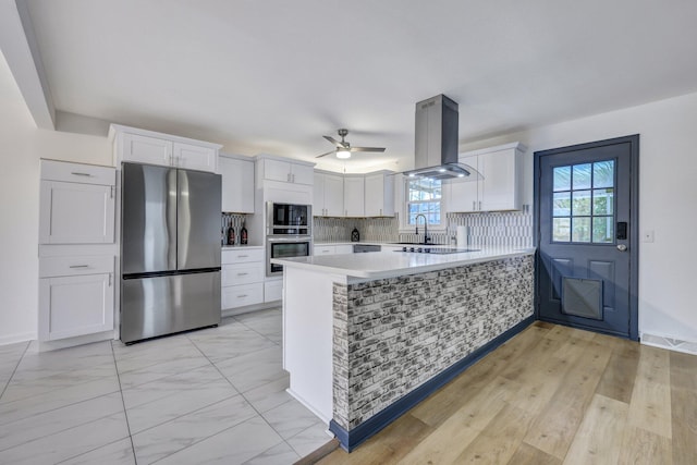 kitchen with white cabinetry, island exhaust hood, freestanding refrigerator, and light countertops