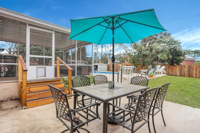 view of patio featuring outdoor dining space, a fenced in pool, a fenced backyard, and a sunroom