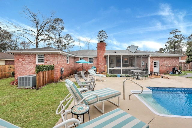 back of property with a lawn, a patio, fence, a sunroom, and a chimney