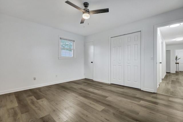 unfurnished bedroom with a ceiling fan, wood finished floors, and baseboards