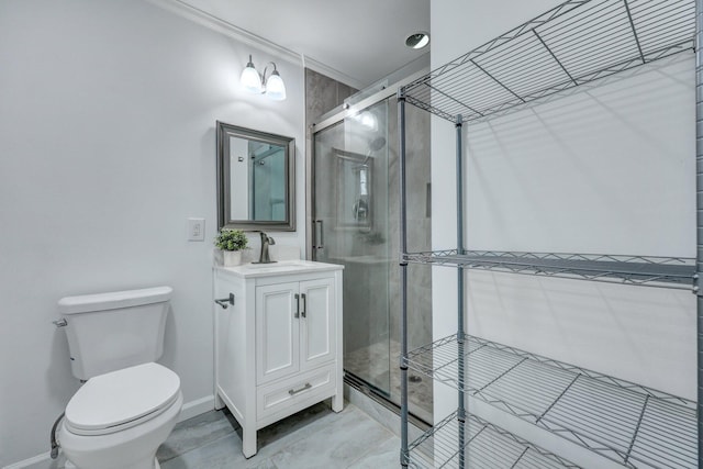 bathroom featuring a shower stall, crown molding, baseboards, toilet, and vanity