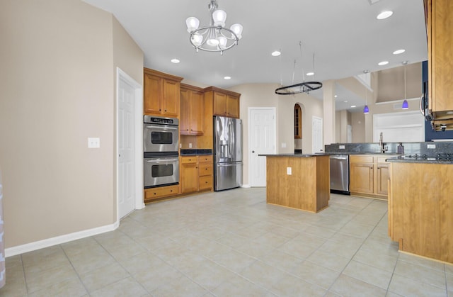 kitchen featuring a notable chandelier, a center island, light tile patterned floors, and appliances with stainless steel finishes