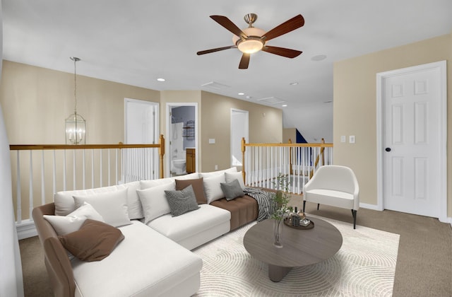 carpeted living room with ceiling fan with notable chandelier