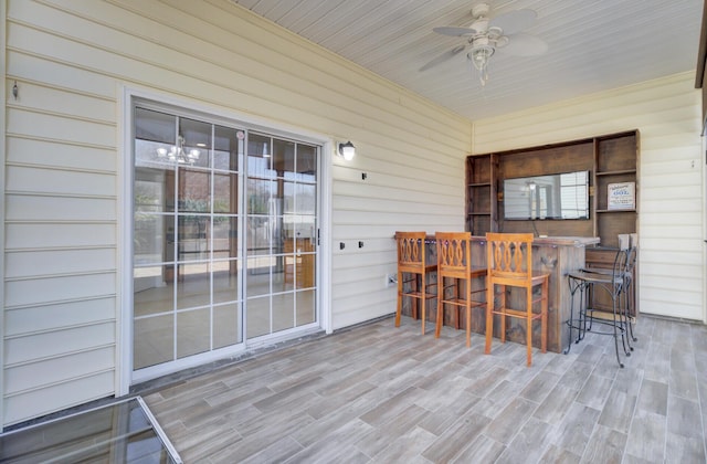 sunroom with ceiling fan and wooden ceiling