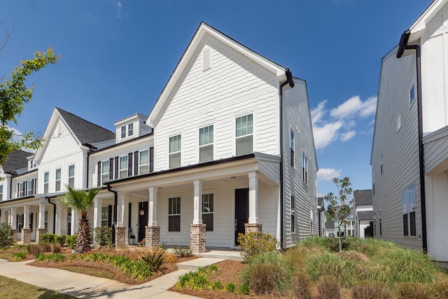 view of property featuring covered porch and a residential view