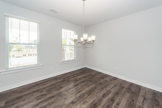 unfurnished room featuring dark wood-style flooring, a notable chandelier, visible vents, and baseboards