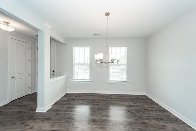 unfurnished dining area featuring visible vents, dark wood-type flooring, baseboards, and a notable chandelier