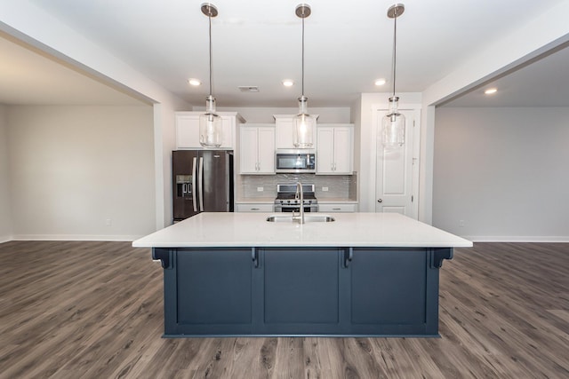 kitchen featuring white cabinets, stainless steel appliances, baseboards, and dark wood finished floors