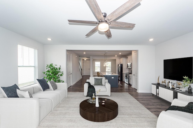 living area with recessed lighting, a ceiling fan, baseboards, and dark wood-style flooring
