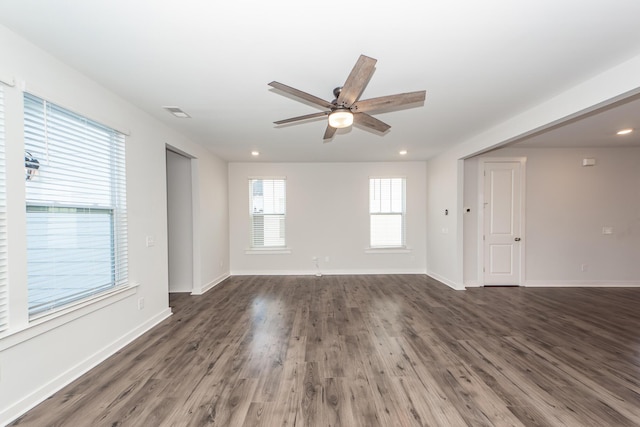 spare room featuring visible vents, baseboards, dark wood-style floors, and ceiling fan