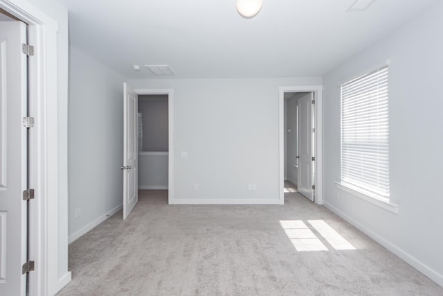 unfurnished bedroom featuring baseboards, carpet, and multiple windows