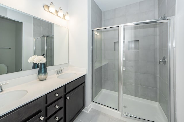 full bath featuring a shower stall, tile patterned floors, and a sink