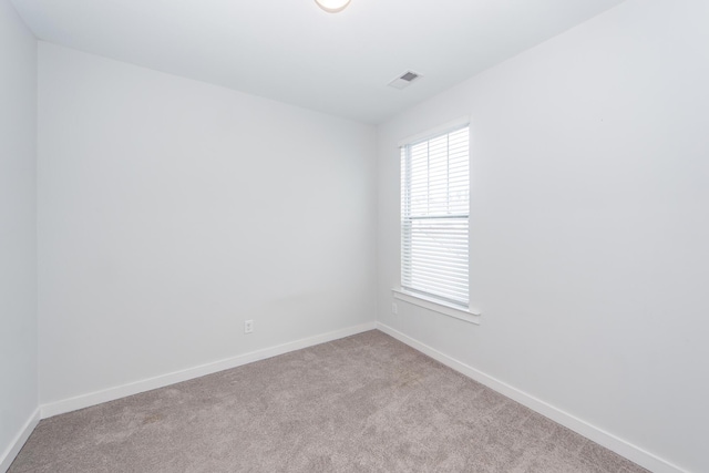 carpeted spare room with baseboards and visible vents