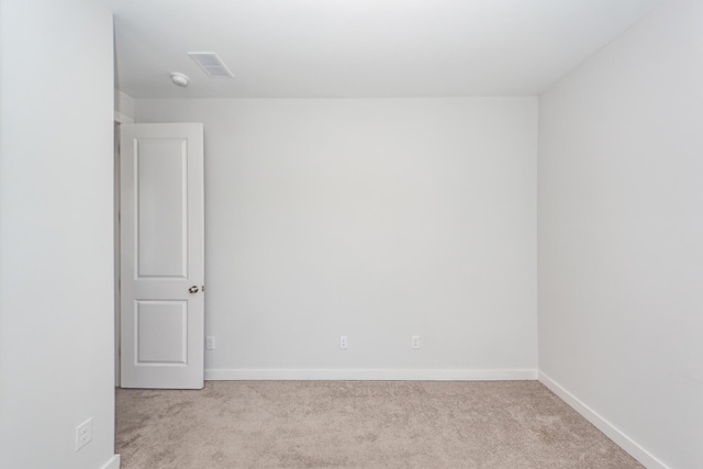 carpeted spare room with baseboards and visible vents