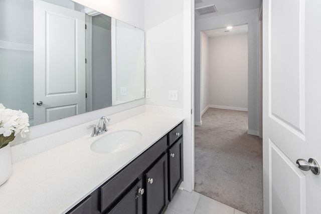 bathroom featuring visible vents, baseboards, and vanity