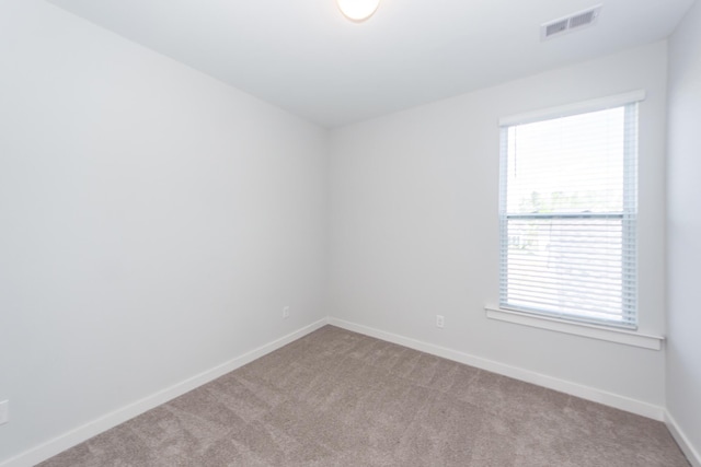 carpeted spare room with baseboards and visible vents