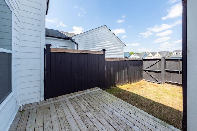 deck featuring a gate, a yard, and a fenced backyard