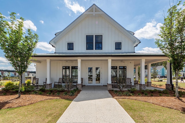 exterior space with a porch, a front yard, board and batten siding, and french doors