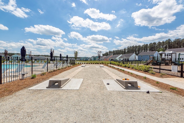 view of property's community with a pool, fence, and a residential view