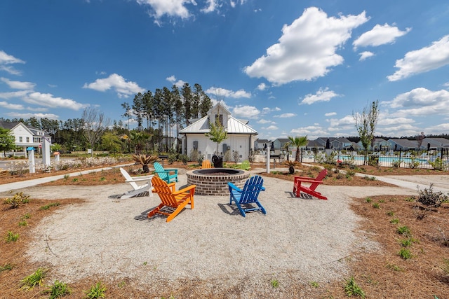 view of playground with a community pool, an outdoor fire pit, and fence