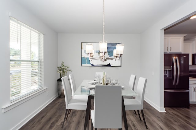 dining area featuring baseboards, a healthy amount of sunlight, dark wood-style floors, and a notable chandelier