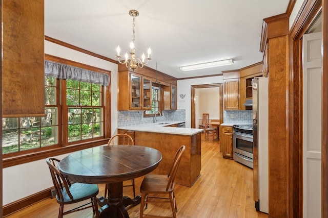 712 Wakendaw Blvd, Mount Pleasant, SC 29464 - kitchen featuring stainless steel appliances, brown cabinetry, a chandelier, light wood finished floors, and light countertops
