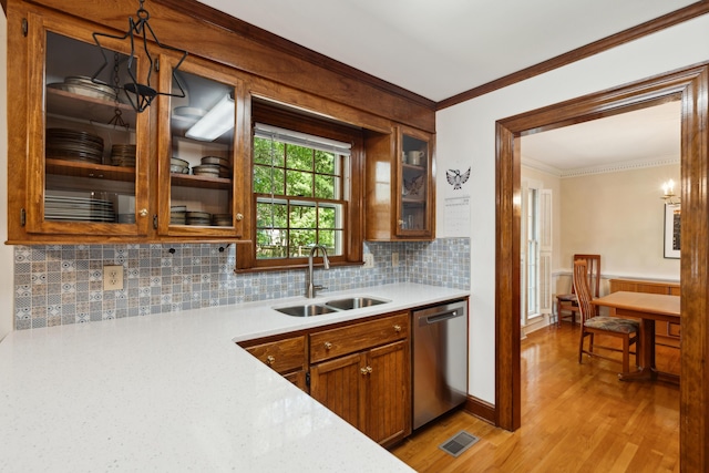 712 Wakendaw Blvd, Mount Pleasant, SC 29464 - kitchen with stainless steel dishwasher, light wood-style flooring, light countertops, crown molding, and decorative backsplash