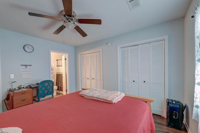 7955 Timbercreek Ln Unit 1807, North Charleston, SC 29418 - bedroom featuring dark wood-type flooring, two closets, connected bathroom, ceiling fan, and a textured ceiling
