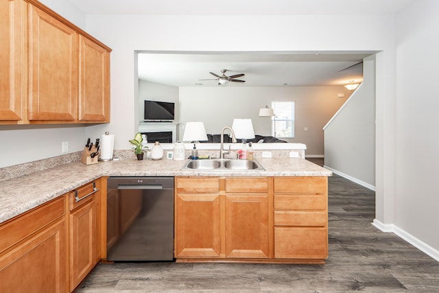 kitchen with a peninsula, wood finished floors, a sink, open floor plan, and dishwasher