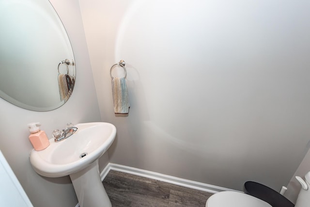 bathroom featuring toilet, baseboards, and wood finished floors