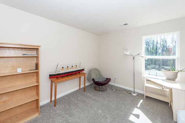 living area featuring carpet floors, visible vents, and baseboards