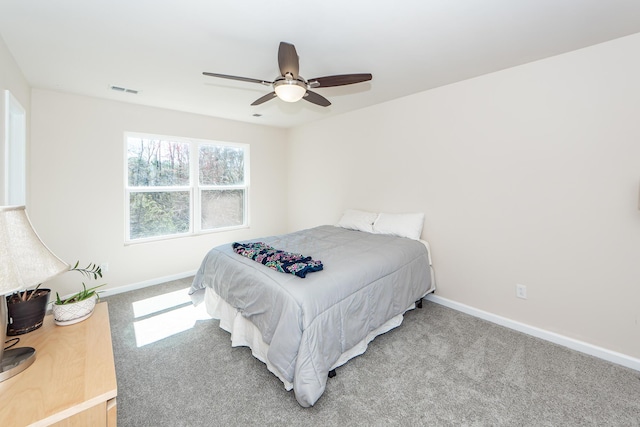 carpeted bedroom featuring visible vents, baseboards, and ceiling fan