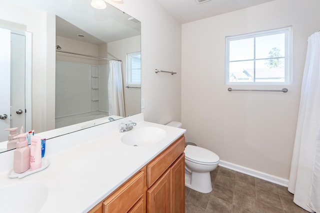 bathroom with curtained shower, toilet, a sink, baseboards, and double vanity