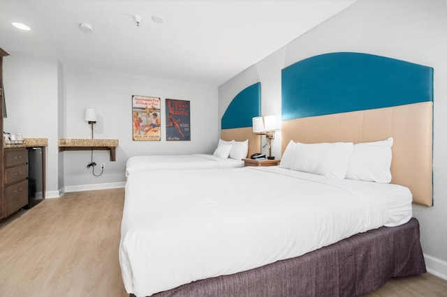 bedroom with baseboards, recessed lighting, and light wood-style floors