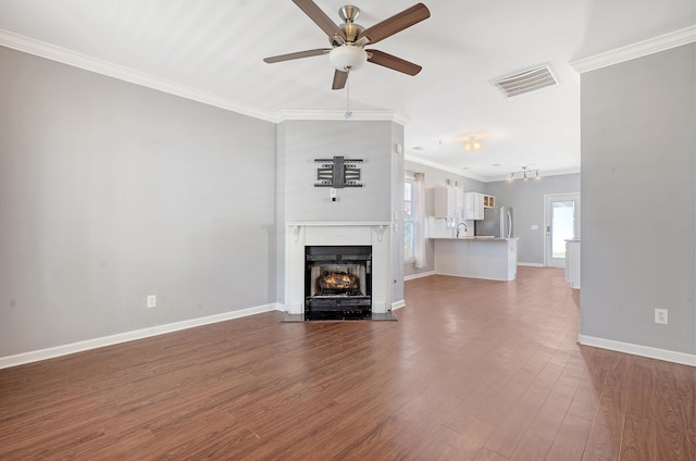 unfurnished living room with hardwood / wood-style floors, ceiling fan, and crown molding