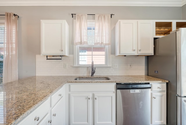 kitchen featuring light stone counters, stainless steel appliances, white cabinetry, and sink