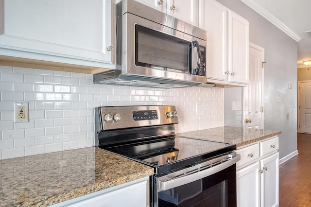 kitchen featuring white cabinets, light stone counters, appliances with stainless steel finishes, and tasteful backsplash