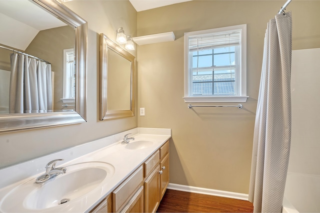 bathroom featuring vaulted ceiling, vanity, shower / tub combo, and hardwood / wood-style flooring