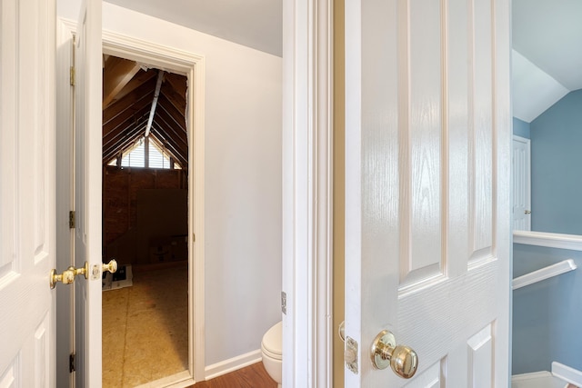 bathroom with toilet, wood-type flooring, and vaulted ceiling