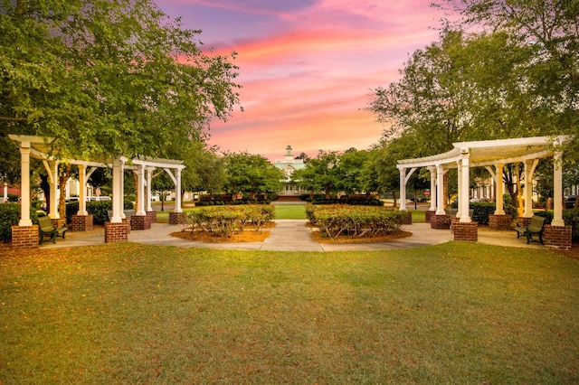 yard at dusk featuring a pergola