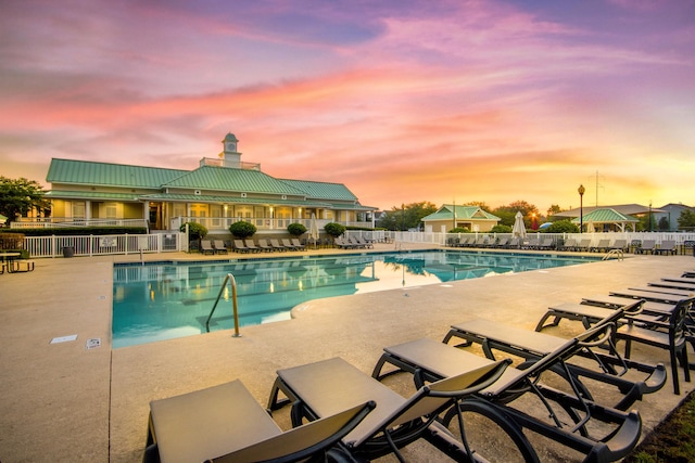 pool at dusk with a patio