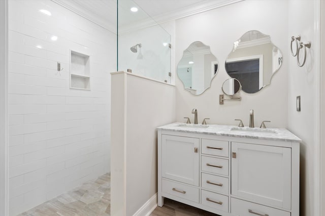 full bathroom with ornamental molding, walk in shower, double vanity, and a sink